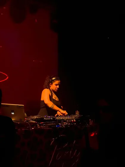 A shot of me mixing during a private gig with dramatic red lighting, creating a sophisticated and energetic mood.