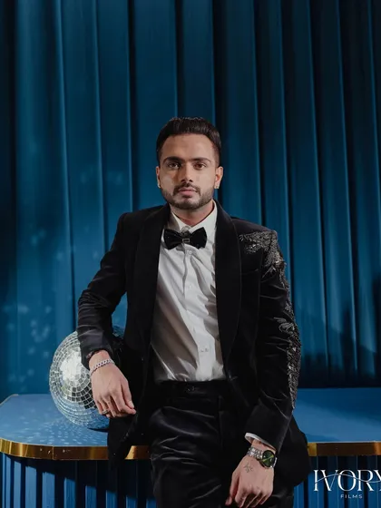 A modern groom's portrait. Posed against a bold blue backdrop with a disco ball, this shot is stylish, confident, and full of personality.