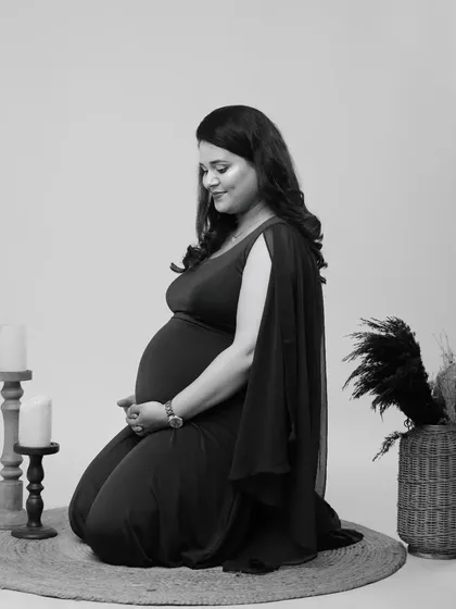 Timeless and elegant. This black and white solo portrait captures a moment of quiet contemplation, focusing on the beautiful silhouette of the mother-to-be.