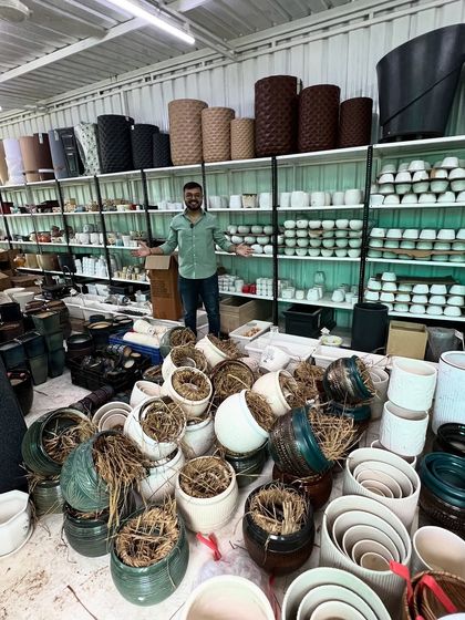 Here I am, surrounded by a mountain of new pots that have just arrived. I take great pride in offering an unmatched variety of stylish and durable planters.