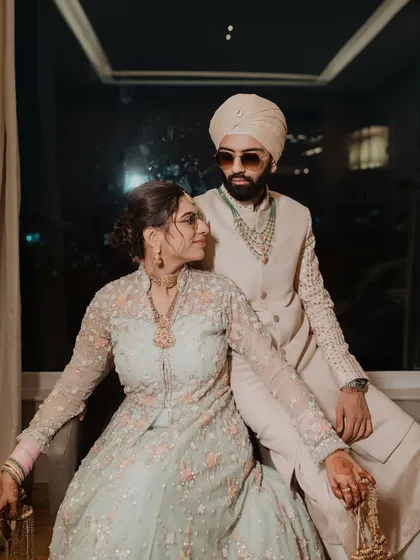 A stylish portrait of the Punjabi bride and groom. Their confident poses and coordinated outfits create a modern and regal look.