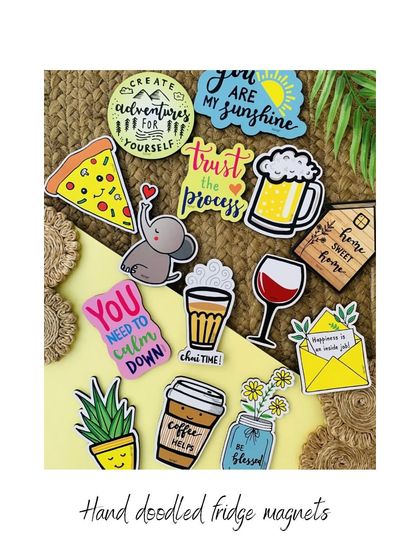 A collection of our little handmade creations, all priced under ₹500. This image shows our hand-doodled fridge magnets with various fun designs and quotes, perfect for adding a bit of joy to your kitchen.