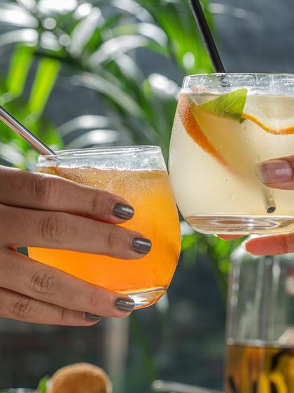 A toast to the weekend. Two friends clinking glasses of our refreshing mocktails.