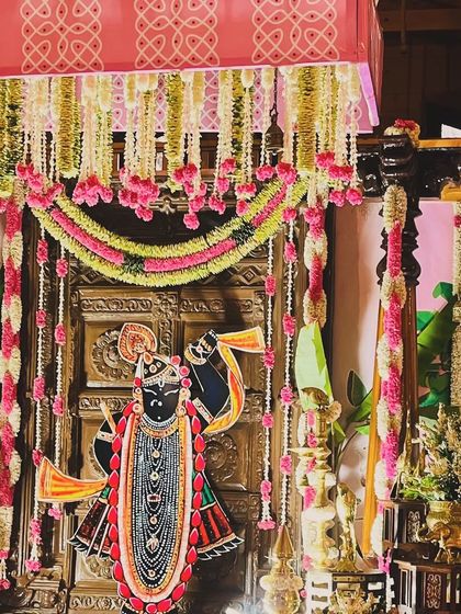 For this naming ceremony, I used a beautiful cutout of Srinathji (a form of Lord Krishna) as a central element, placed before a traditional wooden door and adorned with fresh flower garlands.