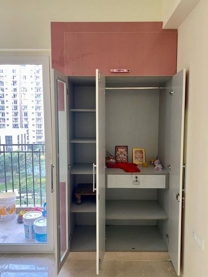 The inside of the kids' wardrobe, showing the practical arrangement of shelves, hanging space, and a lockable drawer.
