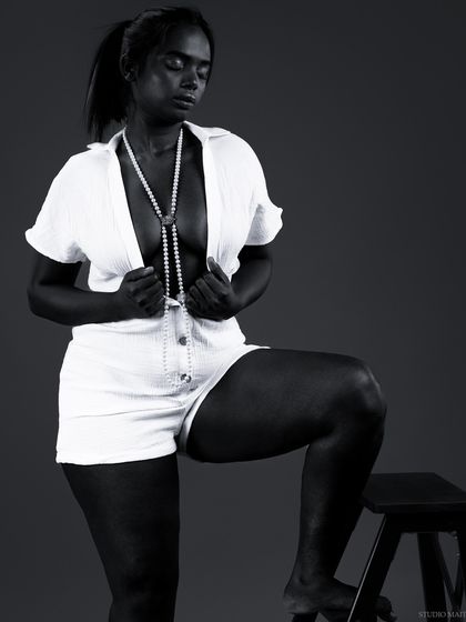 A high-contrast black and white portrait that creates a powerful silhouette. This artistic shot plays with deep shadows and bright highlights.