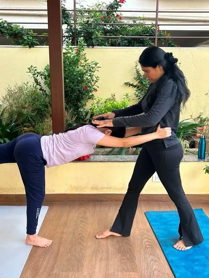 Assisting a student in Virabhadrasana III (Warrior III). With gentle support, I help her find the correct alignment and balance, allowing her to hold the posture with more stability and confidence.