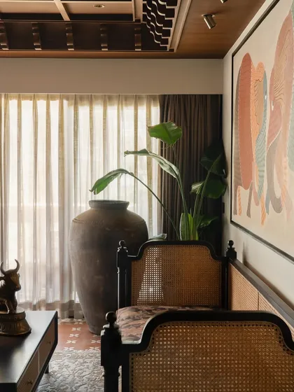 A detail of the living room, with a large urn and plant adding a touch of nature to the interior.