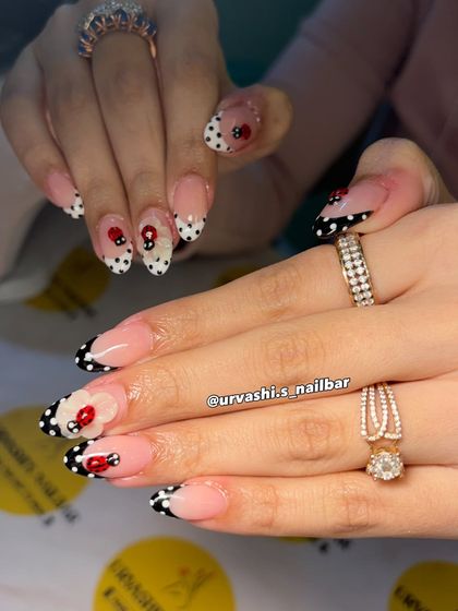 This cute and classy set features hand-painted polka dots and tiny ladybugs. The design uses a modern French tip style in black and white, with the playful bugs adding a whimsical touch.