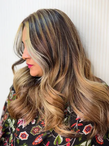 The side profile of this wavy blonde balayage shows how the highlights are expertly placed to create a flattering, dimensional effect.