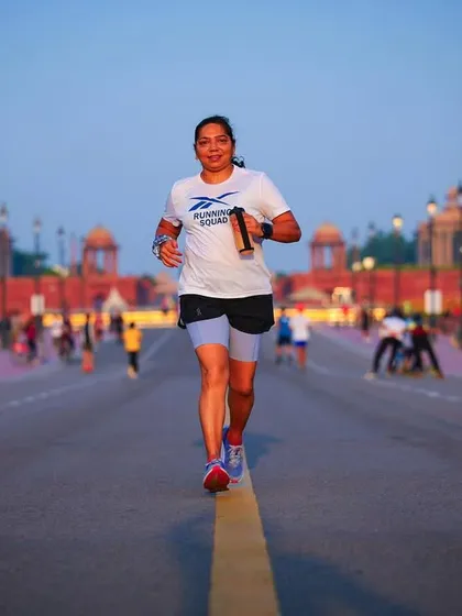 A strong female runner from our squad, smiling through the miles. We foster an inclusive and supportive environment for everyone.