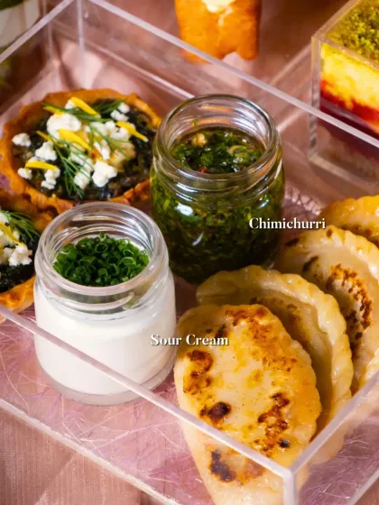 A close-up of some of my fresh, house-made condiments. This image shows my zesty Chimichurri and cool Sour Cream, served alongside pan-fried dumplings.