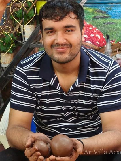 This participant holds two perfectly rolled balls of clay, the foundation for his next creation. Our workshops guide you through the basic steps, ensuring you have a great experience from start to finish.