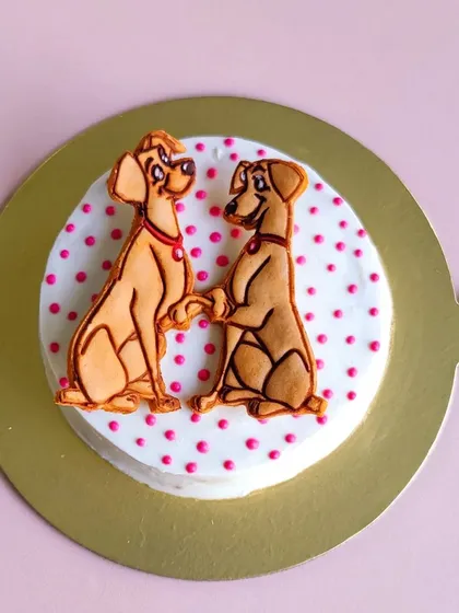 A close-up of our Valentine's cake, featuring a sweet "Lady and the Tramp" inspired cookie topper. It's the perfect way to show your pup some love.