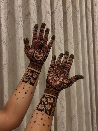 An intricate design featuring a mix of floral mandalas and geometric patterns. The bold wristbands with lotus flowers create a beautiful cuff effect.