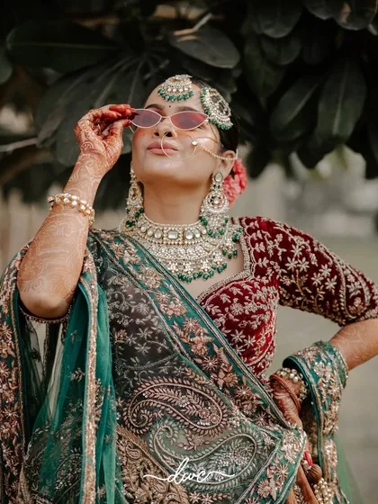 A bride with attitude. This fun and stylish portrait shows the bride in her full traditional glory, playfully adjusting her sunglasses.