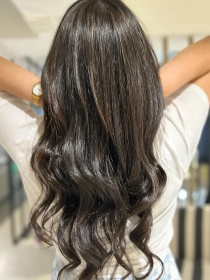 Soft textured bangs with long layers and very subtle peekaboo highlights. This look is all about enhancing the natural hair with a modern cut and a hint of color.