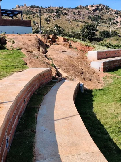 A curved pathway and retaining wall made of brick follow the natural contours of the land at the Nandi Hills site. This shows our approach of working with the existing topography to create organic and integrated landscape designs.