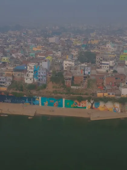 The colorful murals painted along the ghats of Varanasi, seen from the river. It's a blend of ancient tradition and modern art.