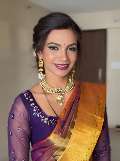 A classic portrait of a smiling bride. The makeup enhances her features beautifully, creating a look that is both glamorous and authentically her.
