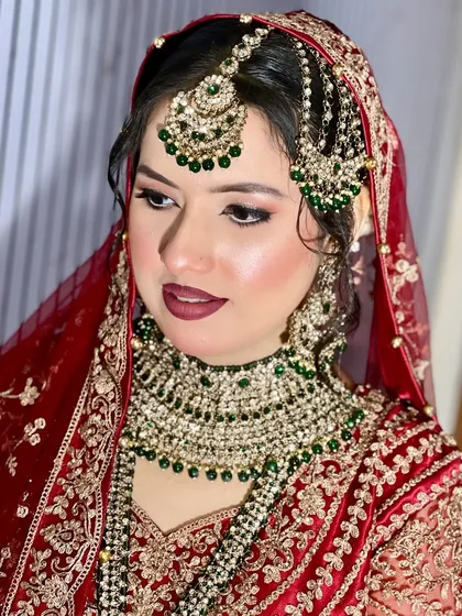 This bride's look is a beautiful example of pairing a red outfit with contrasting green jewellery. I kept the makeup classic with a bold lip and defined eyes to balance the statement pieces.
