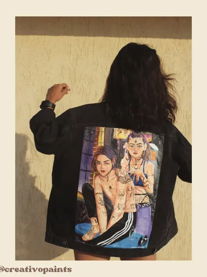 A model wearing the custom-painted jacket, demonstrating how the piece looks in a real-world setting. The detailed artwork on the back is designed to be a conversation starter.