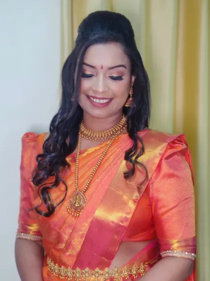 A smiling shot that captures the warmth and radiance of the entire look. The open curls frame her face beautifully.