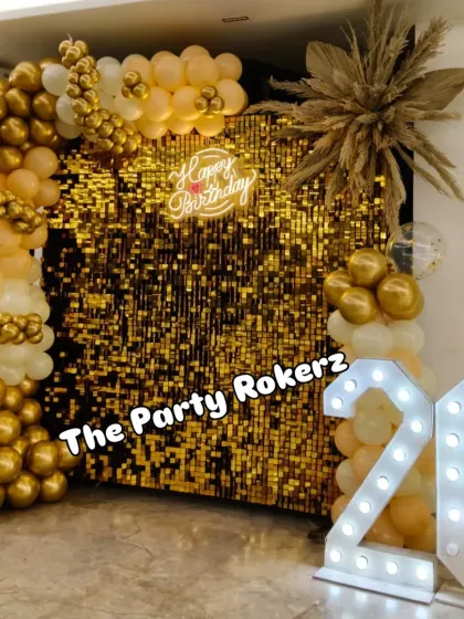 A full view of the glamorous 26th birthday photo corner. The setup includes a gold sequin wall, a neon sign, and a balloon arch with pampas grass details.