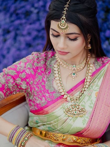 A serene portrait of the bride, showcasing the intricate embroidery on her blouse and the elegant way her jewelry is styled.