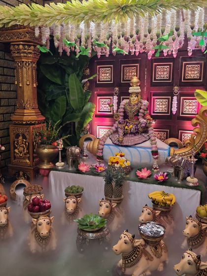 An angled view of the Lakshmi idol setup, showing the traditional pillar and banana leaf decorations.