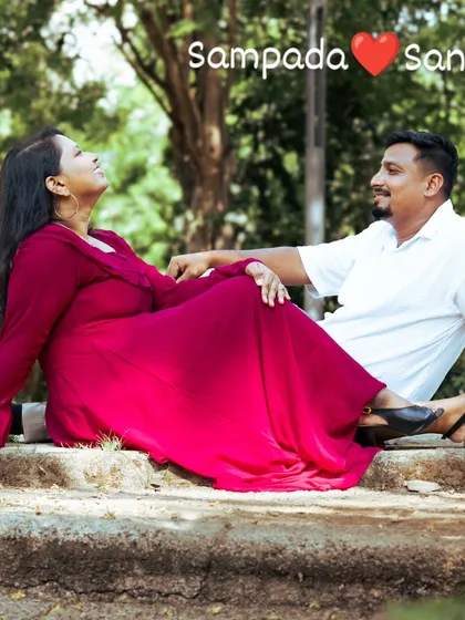 A happy, relaxed moment between a couple sitting together in a park. This candid shot captures their easy laughter and comfortable chemistry, which is the essence of a great pre-wedding photo.