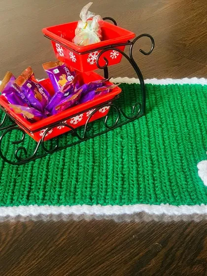The green Christmas placemat with a Santa hat appliqué, styled with a decorative sleigh.