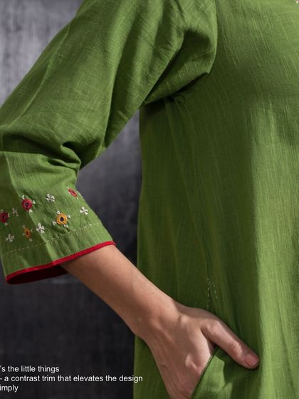 It's the little things that elevate a design. A simple contrast trim on the sleeve of our Paheli green dress adds a thoughtful touch that completes the look.