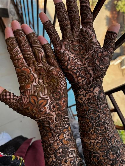 A stunning full-arm design captured in natural daylight, which highlights the different tones in the henna paste and the complexity of the patterns.