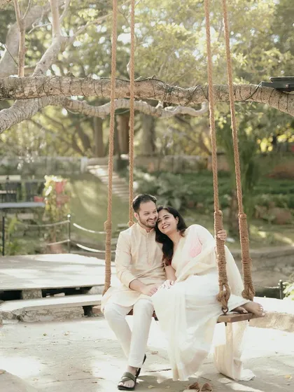 A sweet, relaxed moment on the swing, with the couple looking completely at ease in the serene garden setting.