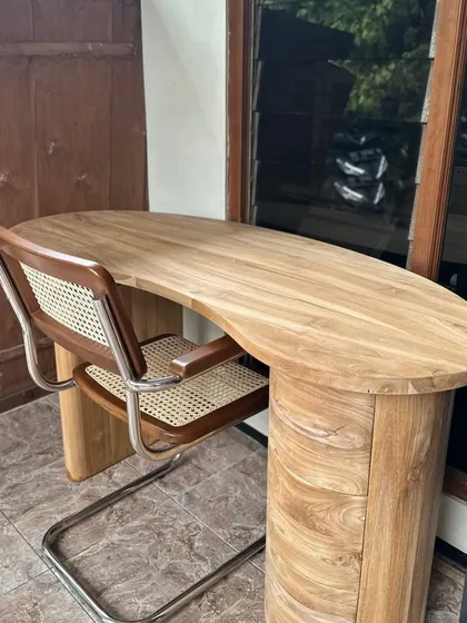 A custom-made study desk with a kidney-bean-shaped top and a cylindrical pedestal base. Paired with a Cesca-style chair, this makes for a stylish and functional home office setup.