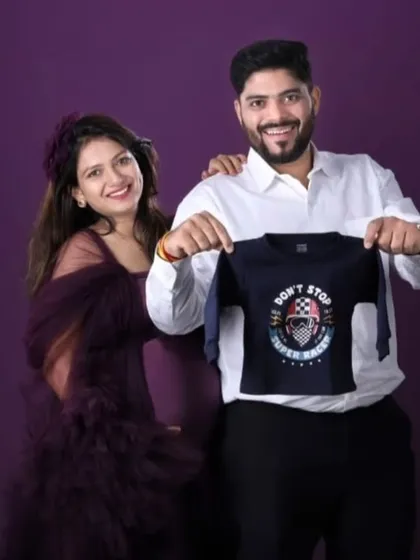 Sharing their excitement with a tiny t-shirt for their future arrival. This couple's maternity photo shows how you can bring personal touches to your shoot, and my wine-colored gown provides the perfect elegant backdrop.