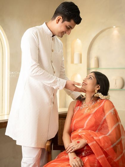 A tender moment in the studio where he gently touches her chin. The soft lighting and warm tones create an atmosphere of pure love and anticipation.