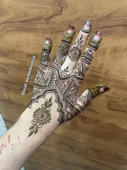 A beautiful design on the back of the hand, featuring a central mandala and detailed finger work.