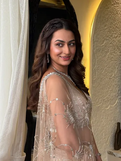A half-up style with a side braid adds a touch of intricate detail to a classic wavy hairstyle, making it perfect for a cocktail party or reception.