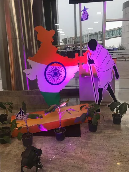This patriotic installation features a cutout of Mahatma Gandhi alongside the map of India, illuminated with purple light. It's a powerful and artistic setup for a corporate or public event.