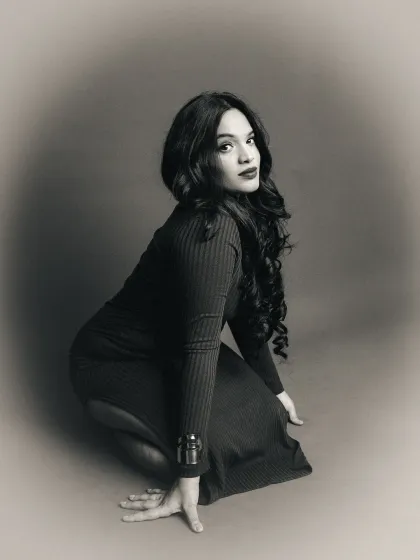 A black and white version of a portrait from the red background series. The monochrome edit with a soft vignette adds a timeless, vintage quality to the image.