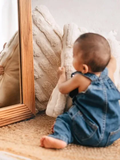 A baby discovers his reflection for the first time. These moments of self-discovery are so precious and make for wonderful, interactive photos.