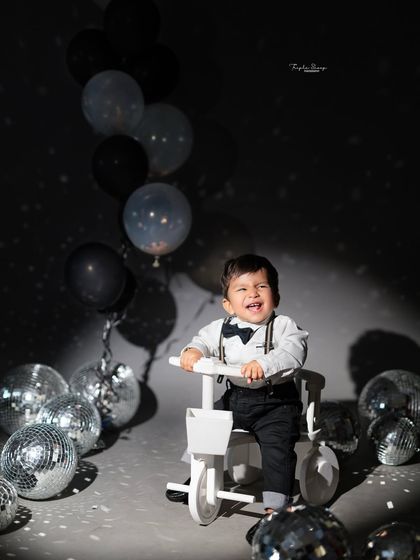 A disco-themed birthday shoot with a cool, modern vibe. The silver disco balls and dramatic lighting create a fun and stylish party atmosphere.