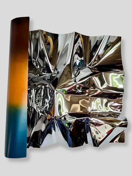 I call this series 'Meteor,' where I work to make rigid stainless steel feel fluid and alive. This wall installation, Meteor 151, uses a color gradient to capture the warmth of a sunset, with the polished surface constantly playing with light and reflection.