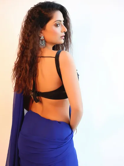 A shot from the back, showcasing the stylish design of the blouse and the elegant drape of the saree. This angle provides a complete view of the outfit.