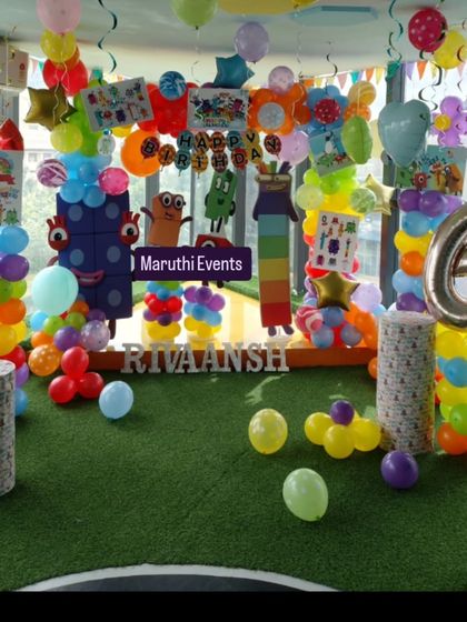 A fun and educational Numberblocks theme for a 6th birthday. This colorful setup includes character cutouts, rainbow balloon columns, and a green turf floor.