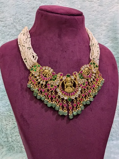 This Jadau choker, with its intricate temple-style design and micro pearl chain, is a work of art. It’s perfect for brides who want a royal and colorful look, blending traditional motifs with the unique beauty of Jadau craftsmanship.