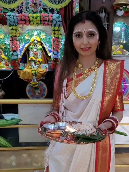 Dressed for Durga Puja, holding a traditional prayer thali. The drape is styled to be both beautiful and practical for participating in rituals, a key consideration in my teaching.