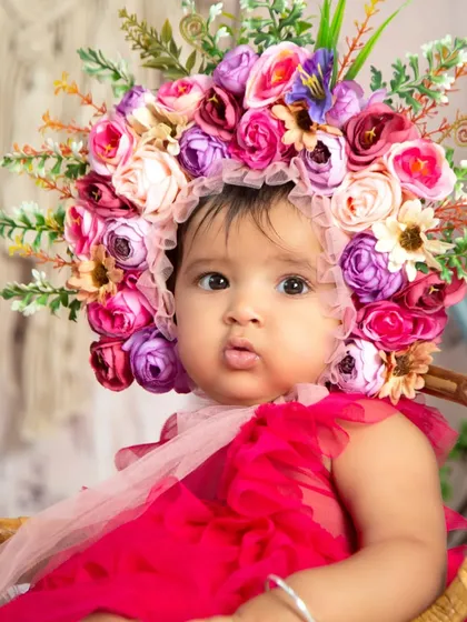 A close-up shot focusing on the beautiful, custom-made floral bonnet worn during a half-birthday session. These little details make each photoshoot unique.
